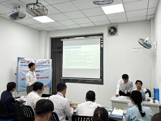 Các sinh viên tập trung vào màn hình máy chiếu, nơi giảng viên đang trình bày các số liệu và kết quả nghiên cứu. Cảnh tượng này thể hiện không khí học thuật, nơi các sinh viên tích cực trao đổi ý tưởng và phương pháp nghiên cứu, phản ánh tinh thần hợp tác và tìm kiếm kiến thức trong nghiên cứu khoa học cấp bộ.